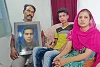 Irfan con i genitori e l’immagine del suo fratello ucciso (csi)